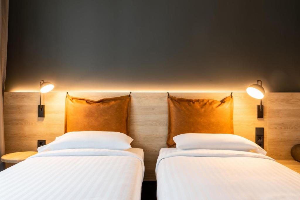 two beds sitting next to each other in a room at Moxy Berlin Airport in Schönefeld