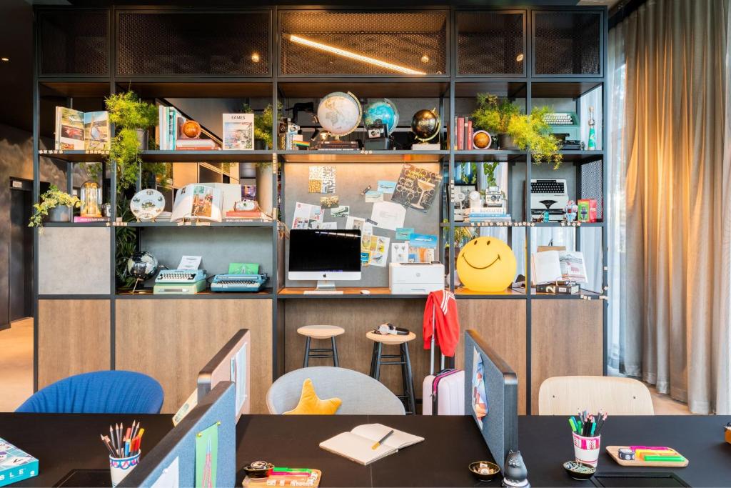 an office with tables and chairs and a desk at Moxy Berlin Airport in Schönefeld
