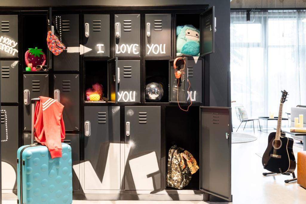 a room with a suit case and a guitar at Moxy Berlin Airport in Schönefeld