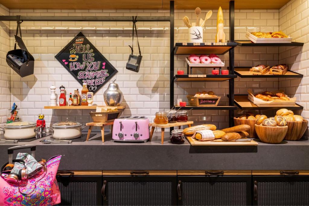 a bakery with bread and pastries on a counter at Moxy Berlin Airport in Schönefeld