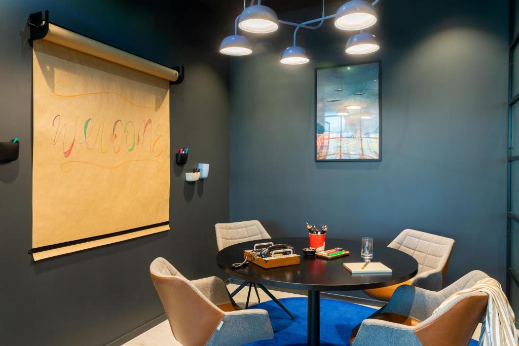 a meeting room with a table and chairs at Moxy Berlin Airport in Schönefeld