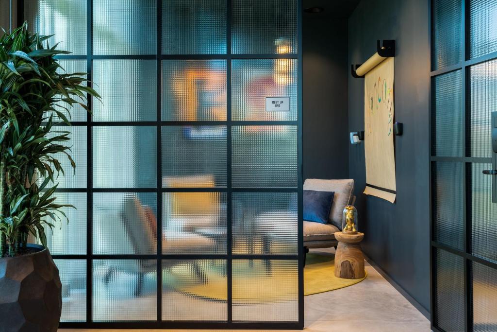 a living room with a sliding glass door at Moxy Berlin Airport in Schönefeld