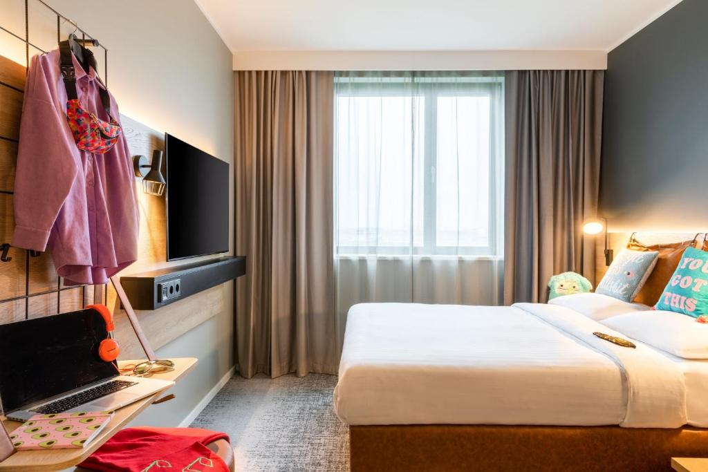 a hotel room with a bed and a window at Moxy Berlin Airport in Schönefeld