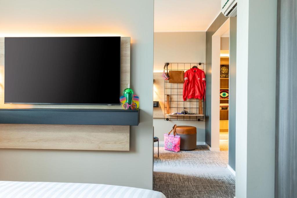 a bedroom with a flat screen tv on a wall at Moxy Berlin Airport in Schönefeld