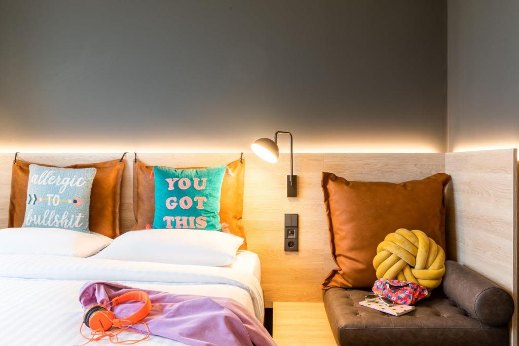 a hotel room with two beds and a couch at Moxy Berlin Airport in Schönefeld