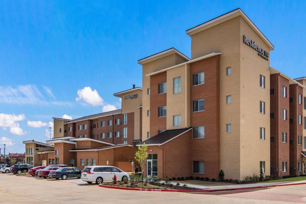 a large brick building with cars parked in a parking lot at Residence Inn by Marriott Dallas DFW Airport West/Bedford in Bedford