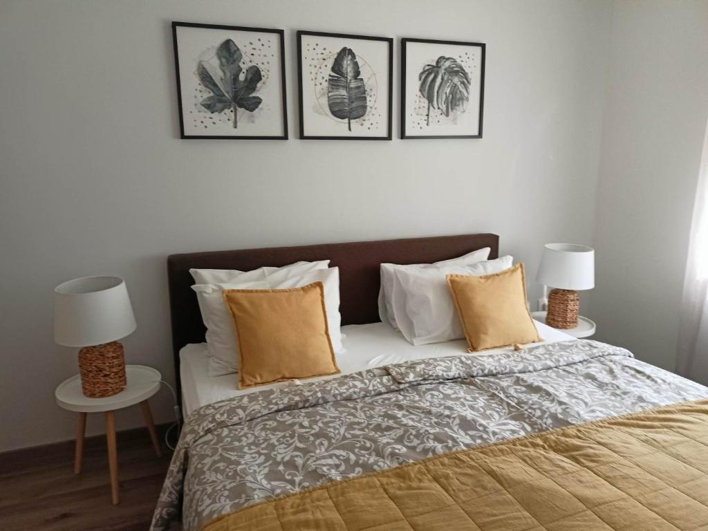 a bedroom with a bed with four pictures on the wall at Centrum Apartman Kőszeg in Kőszeg