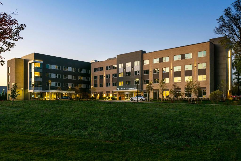 un gran edificio con un campo de césped delante de él en AC Hotel by Marriott Boston Cambridge en Cambridge