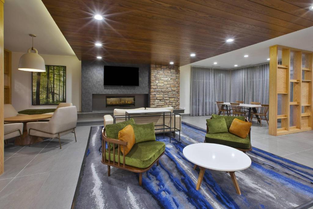 a lobby with chairs and a table and a fireplace at Fairfield Inn & Suites by Marriott Flint Grand Blanc in Grand Blanc