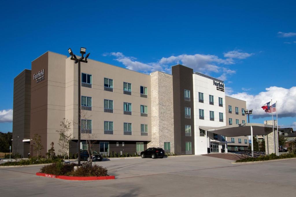 a large building with a car parked in front of it at Fairfield Inn & Suites Houston Katy in Katy