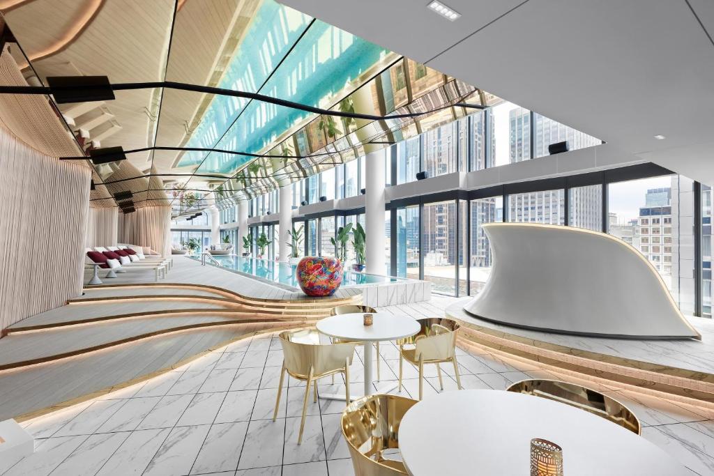 een lobby met tafels en stoelen en grote ramen bij W Melbourne in Melbourne