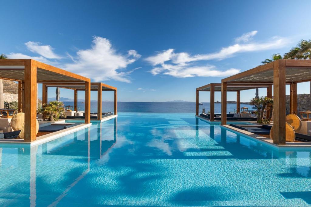 a swimming pool with a view of the ocean at Santa Marina, A Luxury Collection Resort, Mykonos in Ornos