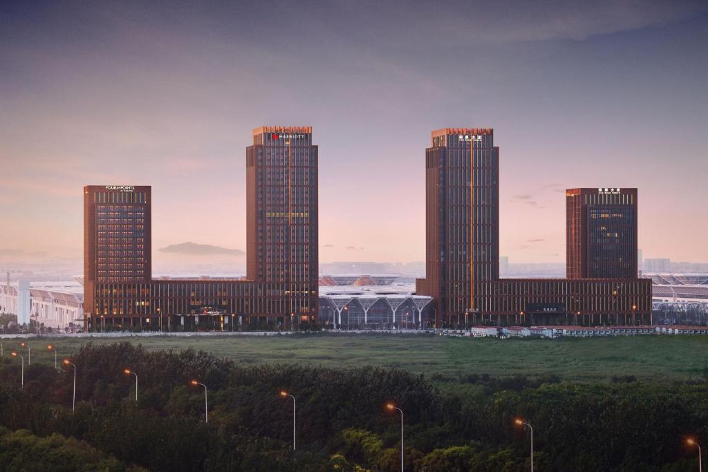 un groupe de grands bâtiments dans une ville dans l'établissement Tianjin Marriott Hotel National Convention and Exhibition Center, à Tianjin