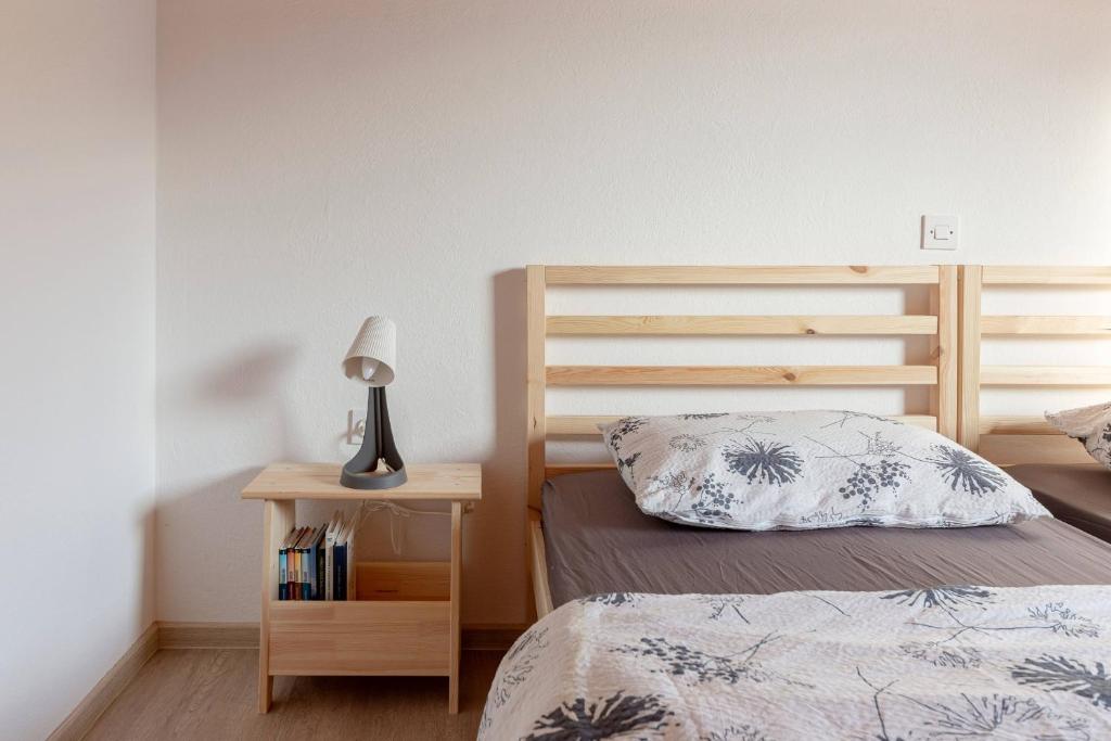 1 dormitorio con cama y mesita de noche con lámpara en Apartments Farm House Uric en Jesenice