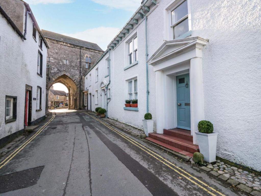 una calle vacía en un callejón con edificios blancos en 1 Tower House, en Grange-over-Sands