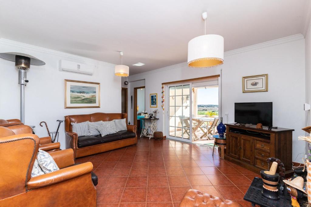 a living room with a couch and a tv at Beach Front View Armacao de Pera Flat huge Terrace in Armação de Pêra