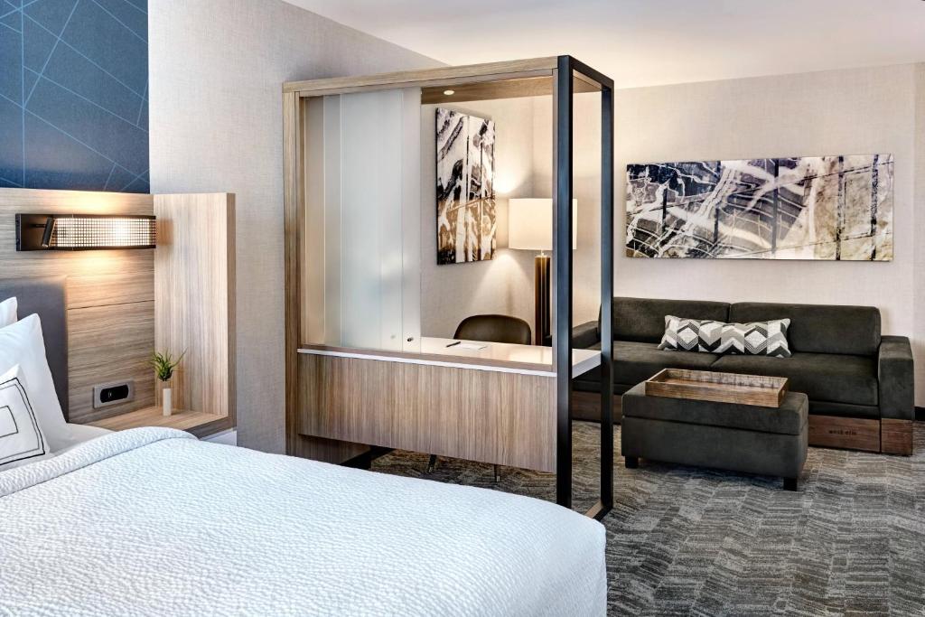 a hotel room with a bed and a couch at SpringHill Suites by Marriott Cleveland Independence in Independence
