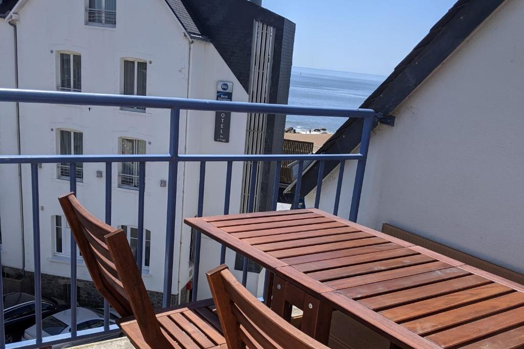 d'un balcon avec une table en bois et deux chaises. dans l'établissement T3 Sea View with beach at 20m Saint-Marc-sur-Mer, à Saint-Nazaire