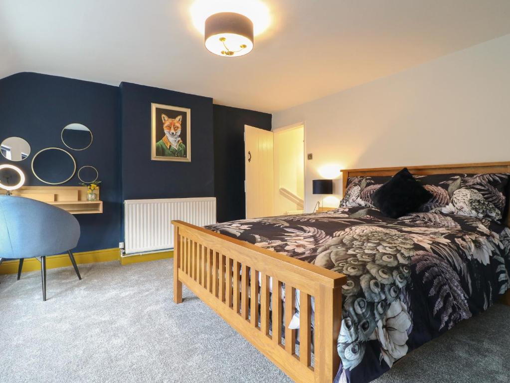 a bedroom with a bed and a blue wall at The Foxes Den in Totmonslow