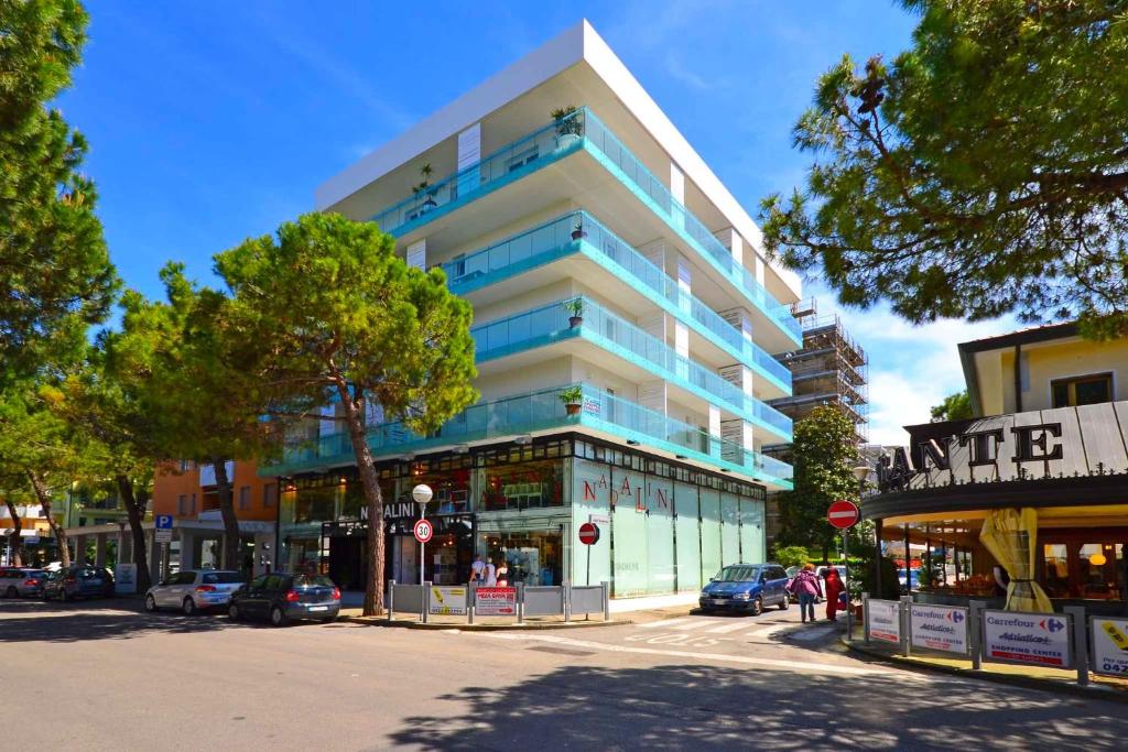 a building on a street with cars parked in front of it at Apartments in Lignano 21707 in Lignano Sabbiadoro