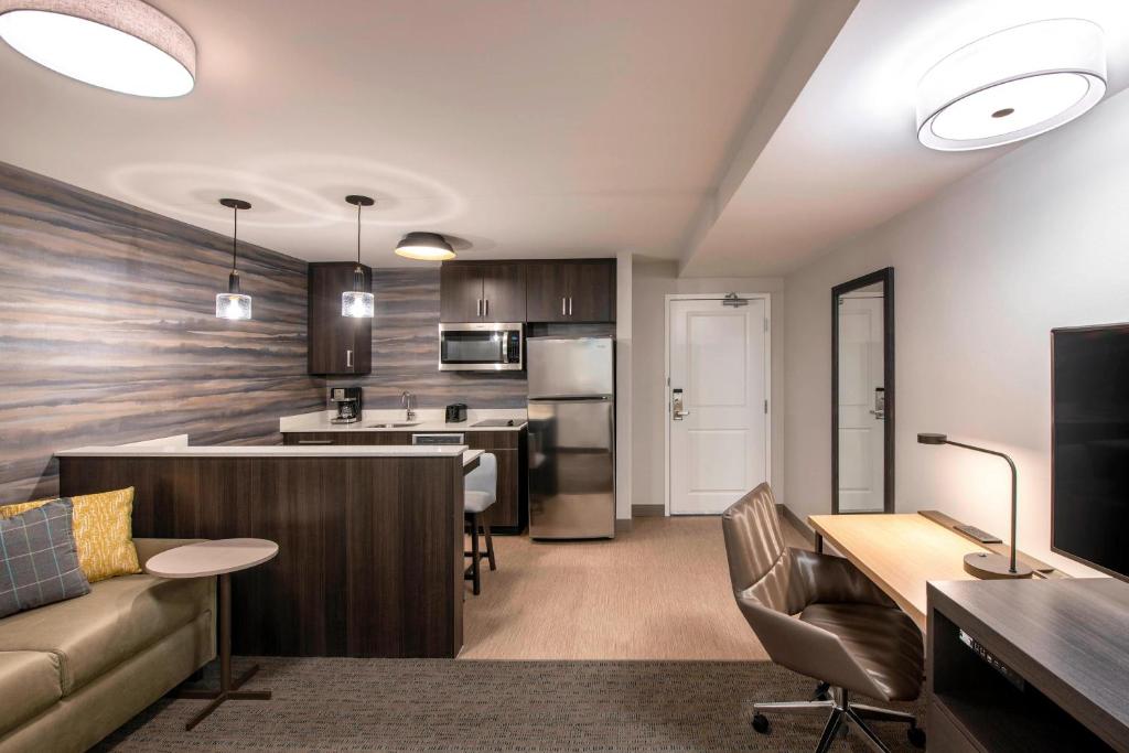 a kitchen and living room with a couch and a table at Residence Inn by Marriott Winnipeg in Winnipeg