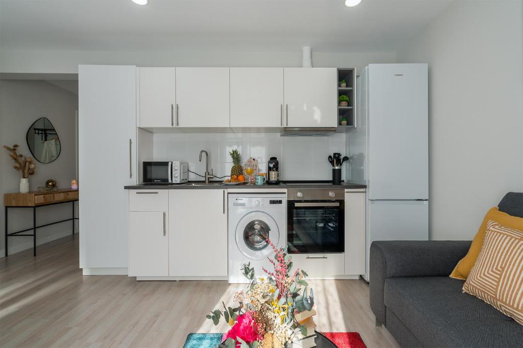 a kitchen with white cabinets and a washing machine at Apartamento Hospital Cruces - BEC in Barakaldo