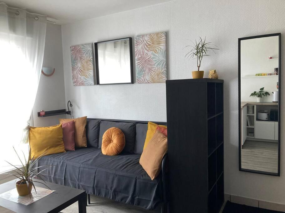 a living room with a blue couch with pillows at Cozy'Nest in Brest