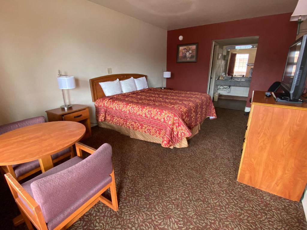 um quarto de hotel com uma cama e uma mesa em Travel Inn lackland Sea World em San Antonio