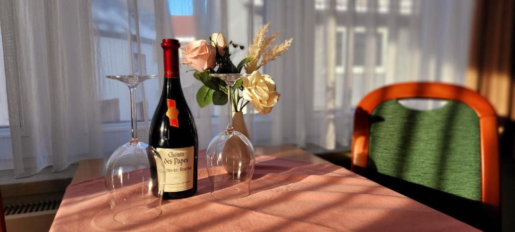 - deux bouteilles de vin et des vases avec des fleurs sur une table dans l'établissement Zum Unstrut Radler, 
