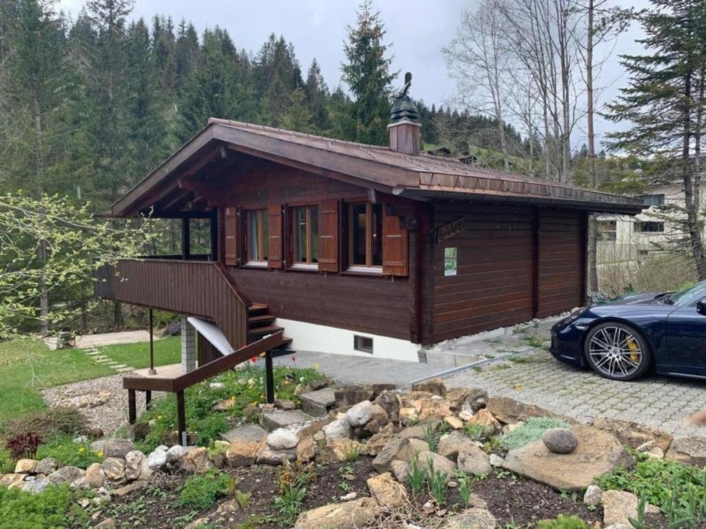 una pequeña casa con un coche aparcado delante de ella en Chalet Bambi, en Sörenberg