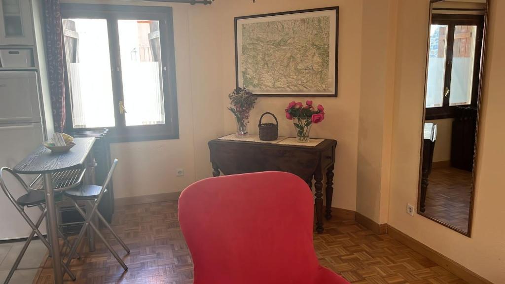 sala de estar con silla roja y mesa en Apartamento Bubal, en Panticosa