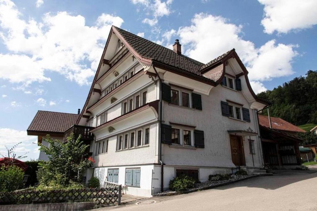 a large white house with a brown roof at Haus zum Reh in Krummenau
