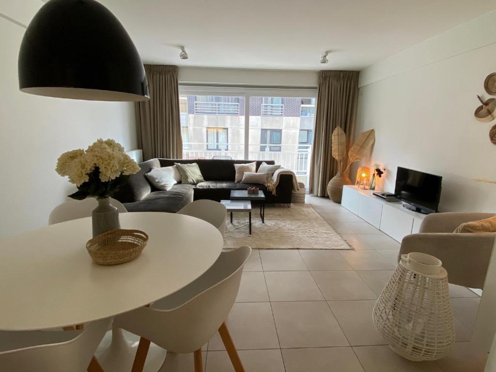 a living room with a table and a couch at Apartment Zin in Zee in Knokke-Heist