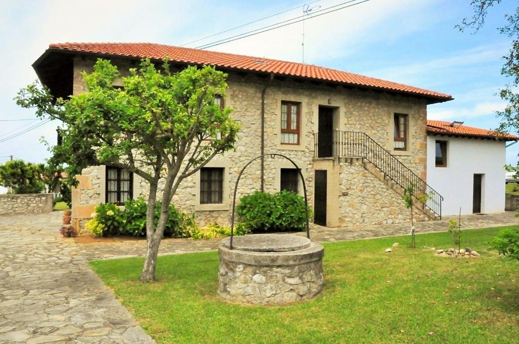 a stone house with a tree in front of it at Apartamentos Maite in Oreña