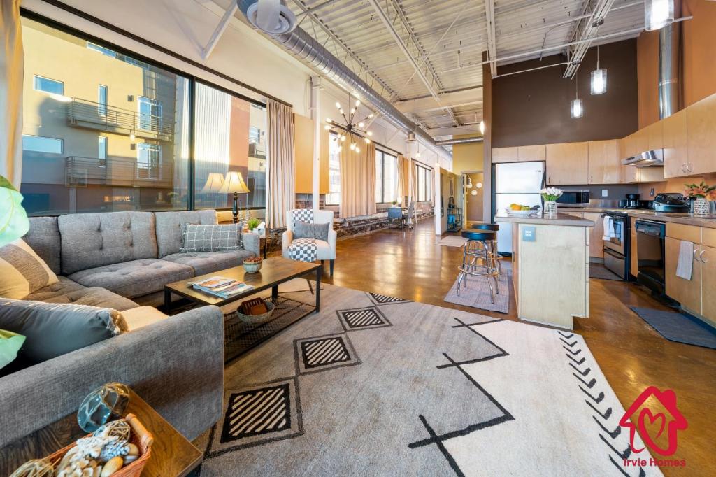 a large living room with a couch and a kitchen at Elevated Route 66 ABQ Penthouse- An Irvie Home in Albuquerque