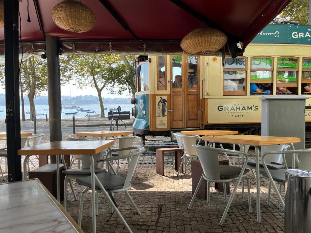 um restaurante com mesas e cadeiras em frente a um autocarro em Porto Plage de Matosinhos em Matosinhos
