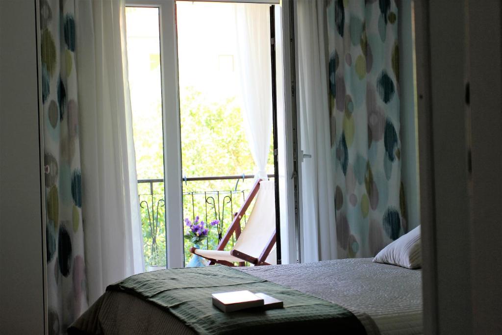 1 dormitorio con 1 cama y ventana con balcón en Rooms Ena Rovinj, en Rovinj