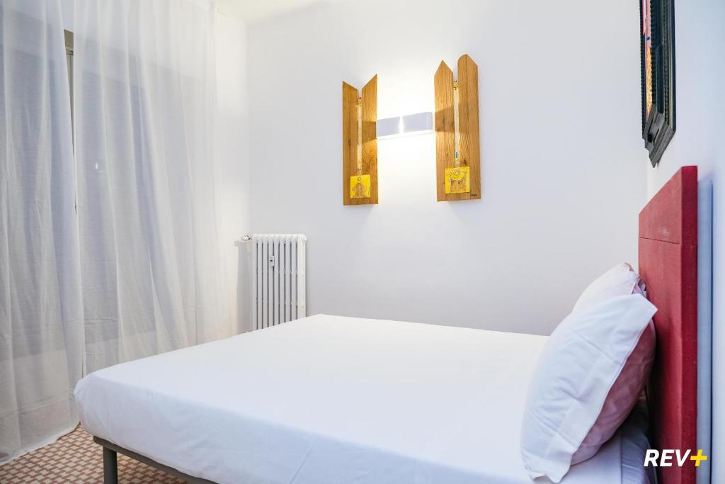um quarto com uma cama branca e duas fotografias na parede em Lia Art Hotel em La Spezia