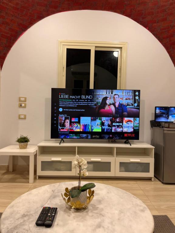 a living room with a large flat screen tv at Sahure Pyramid View Inn in Cairo