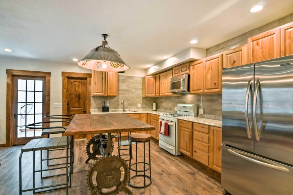 a kitchen with wooden cabinets and a stainless steel refrigerator at Updated Main St Apt Near Fishlake and Capitol Reef! in Salina