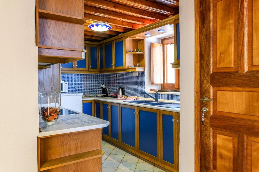 eine Küche mit blauen Schränken und einem weißen Kühlschrank in der Unterkunft Dimele in Mykonos Stadt