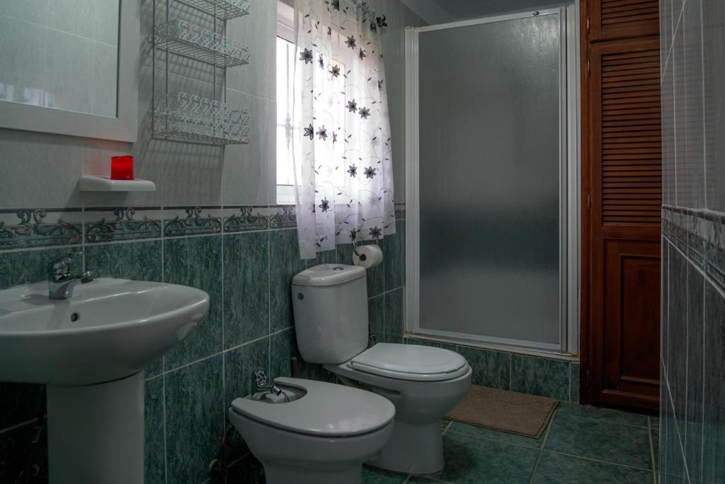 uma casa de banho com um WC, um lavatório e uma janela em Villa Bravo em Partaloa