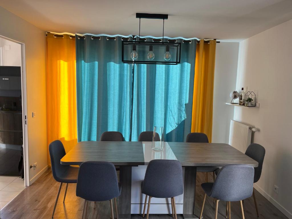 a dining room with two wooden tables and chairs at Appartement de Romainville in Romainville