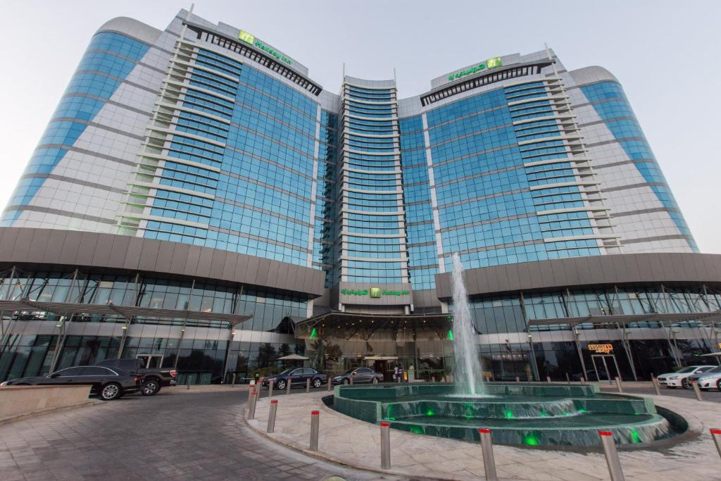 twee hoge gebouwen met een fontein ervoor bij Holiday Inn Abu Dhabi, an IHG Hotel in Abu Dhabi