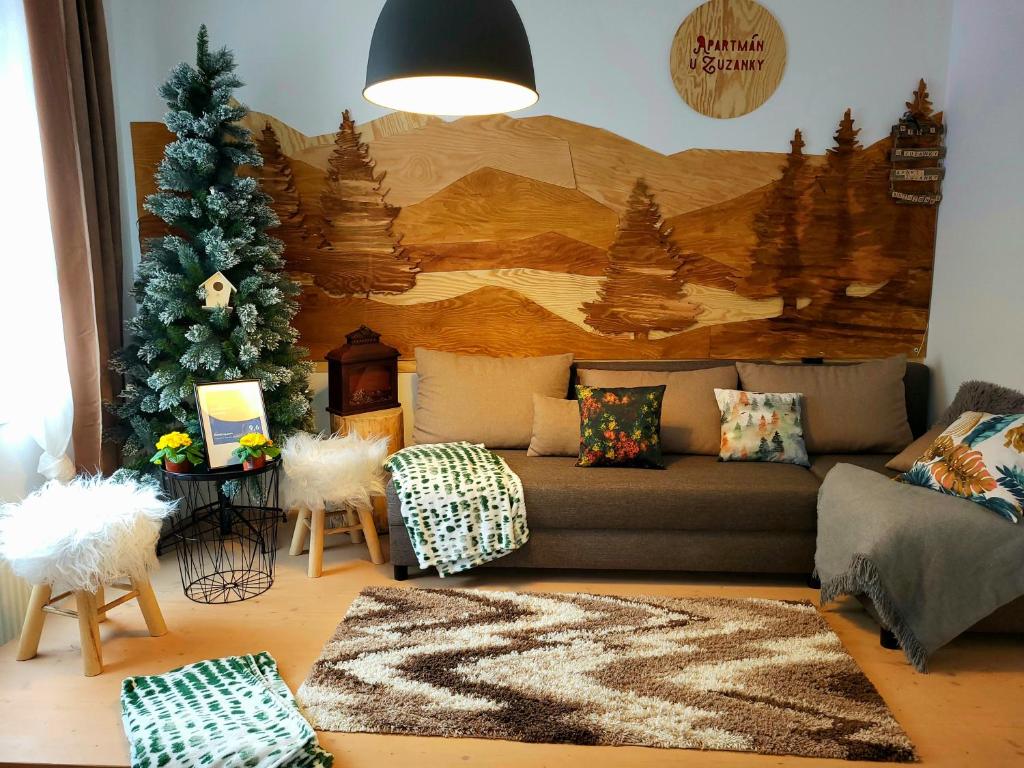 a living room with a couch and a christmas tree at Apartmán u Zuzanky in Svoboda nad Úpou
