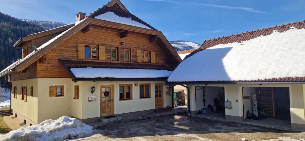 a wooden house with snow on the roof at Ferienhaus Michael in Bad Kleinkirchheim