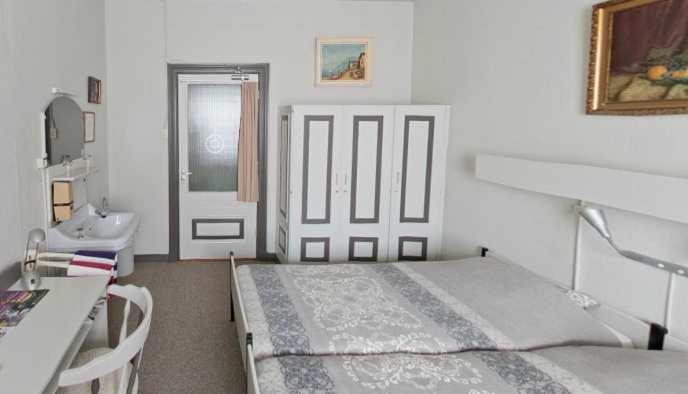 een slaapkamer met een bed, een bureau en een deur bij Hotel Domstad in Utrecht