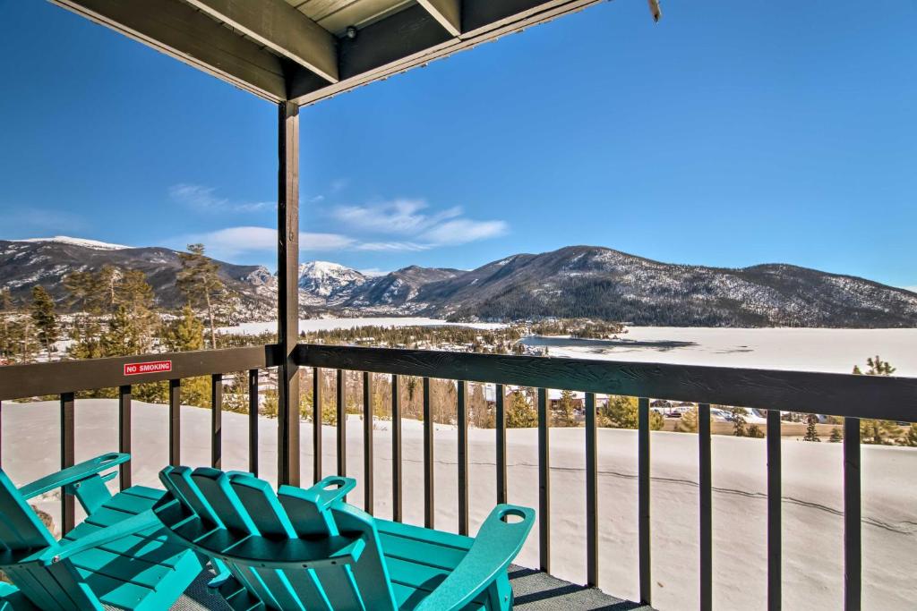 a porch with blue chairs and snow covered mountains at Updated Condo with Views and Deck Less Than 1 Mi to Grand Lake in Grand Lake