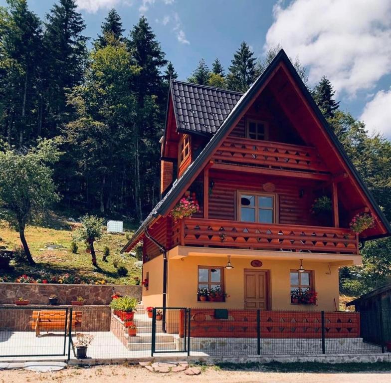una pequeña casa de madera con techo rojo en Planinska kuca za odmor-Mlinista, en Landeke