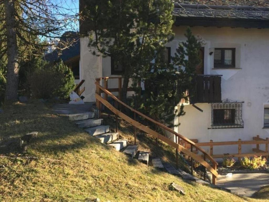 uma casa com uma cerca e escadas em frente em Chesa Linaira em Pontresina